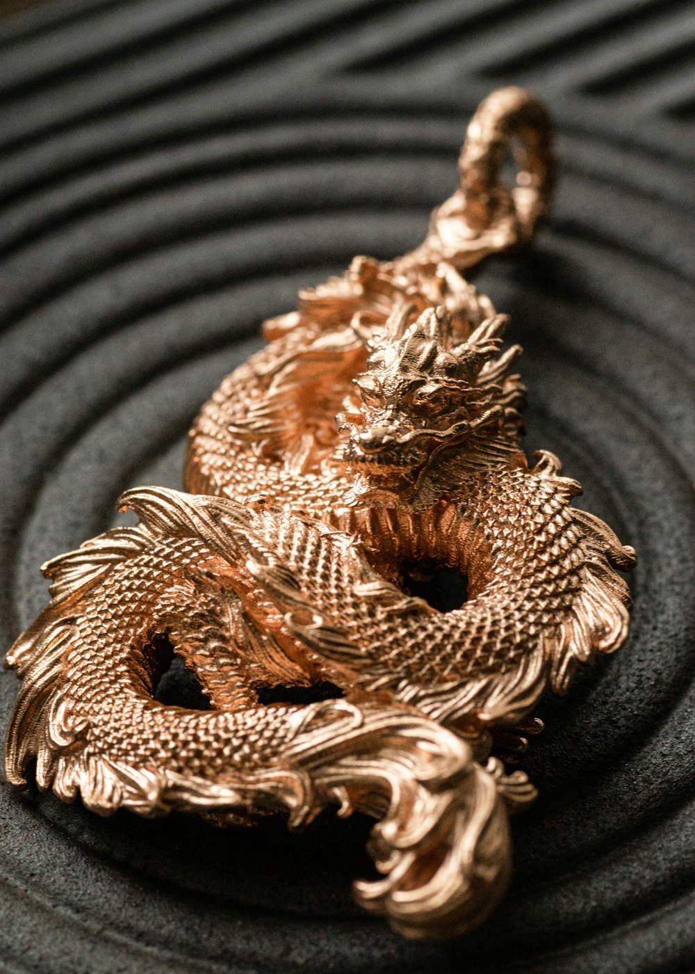 a gold dragon keychain on a black background