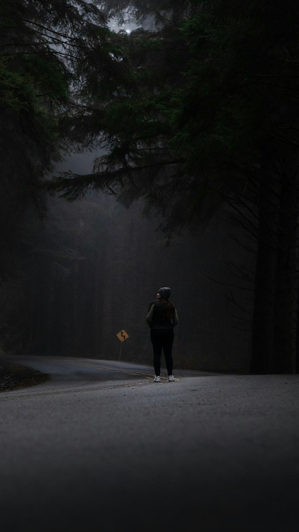a person walking down a road in the dark