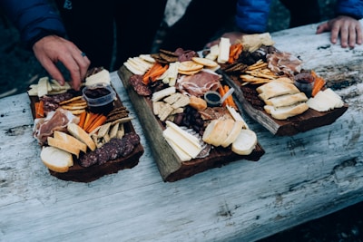 a couple of trays of food sitting on top of a wooden table