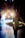 A ballerina in a tutu stands backstage, silhouetted against bright stage lights. Other dancers are visible in the background, preparing for a performance. The scene captures the anticipation and focus of a dance production.