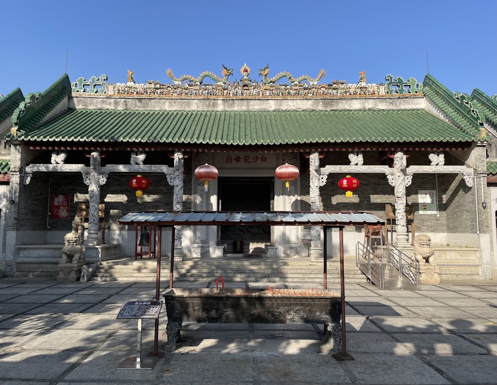 a chinese building with a green roof and red lanterns