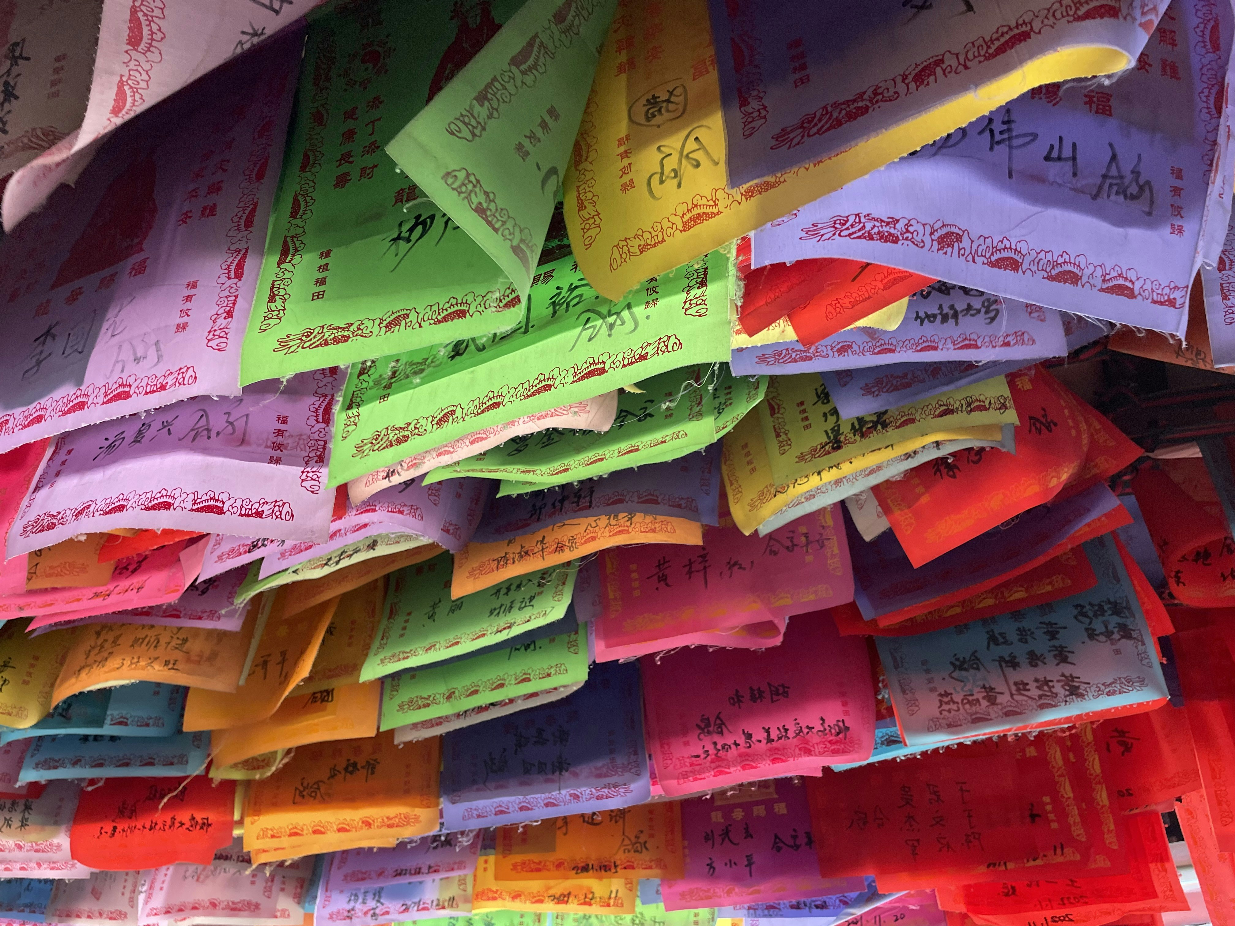 a bunch of colorful bags hanging from a ceiling