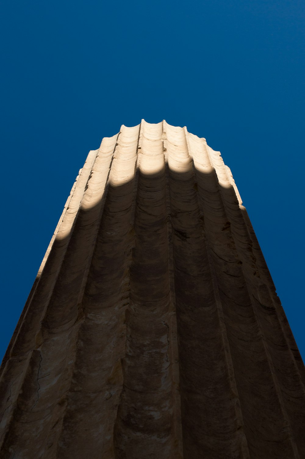 the top of a tall building with a blue sky in the background