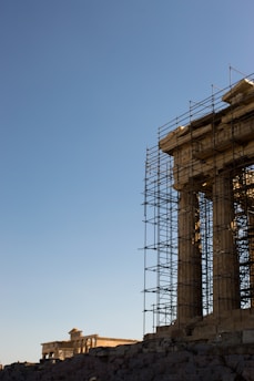 scaffolding on the side of a building with a clock tower in the background