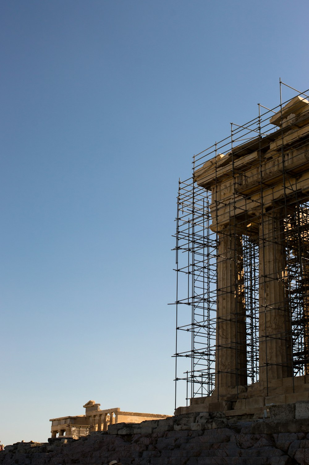 scaffolding on the side of a building with a clock tower in the background