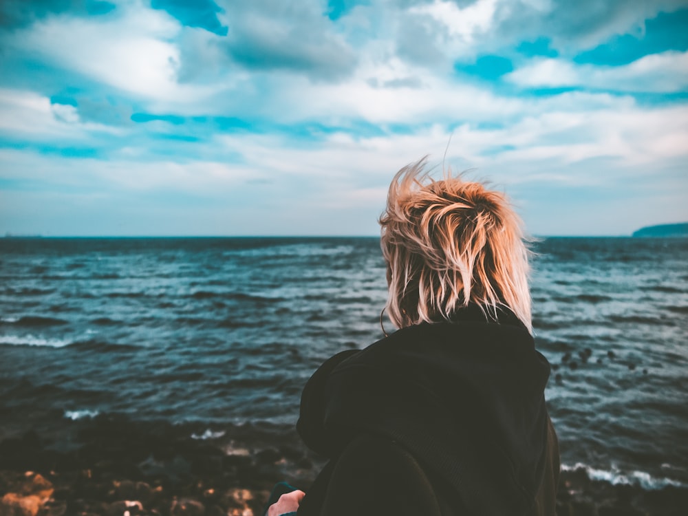 a person standing on a beach looking out at the ocean