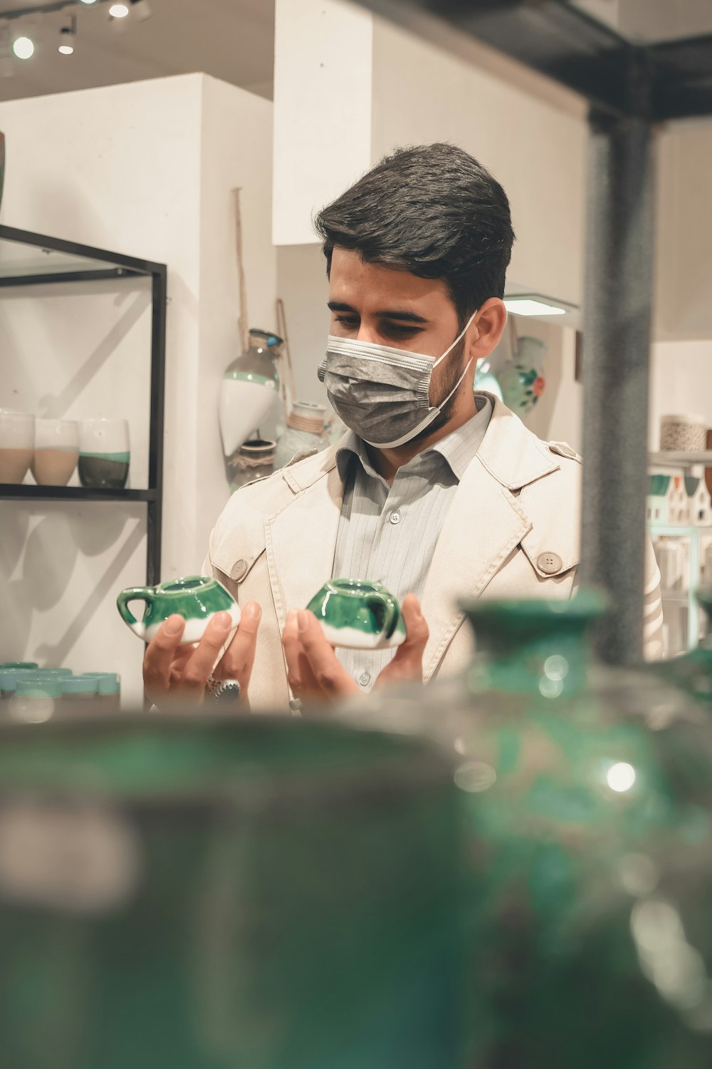 a man wearing a face mask and holding a cup