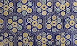 Hexagonal tiles featuring intricate floral patterns in vibrant colors are arranged in a repeating geometric pattern. Each tile contains stylized flowers with yellow, green, and white petals surrounding a central circular design, set against a deep blue background.