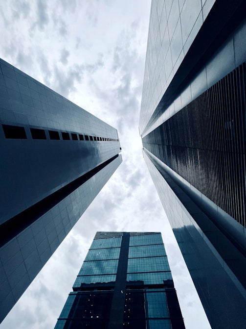 looking up at two tall buildings in a city