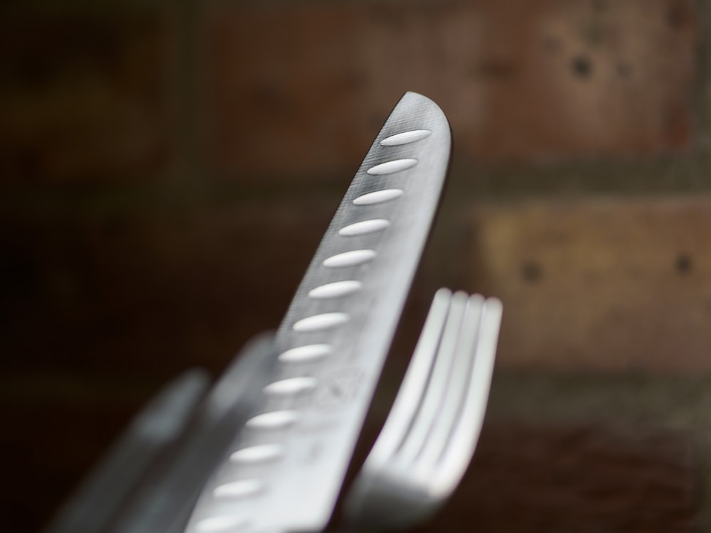 a close up of a fork with a brick wall in the background