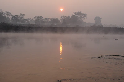 Early morning view of the Ganga river with soft sunlight and mist.