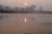 A peaceful riverside scene at dawn with soft light reflecting on the water.