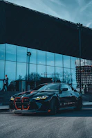 A business traveler stepping out of a luxury car in front of a corporate office.