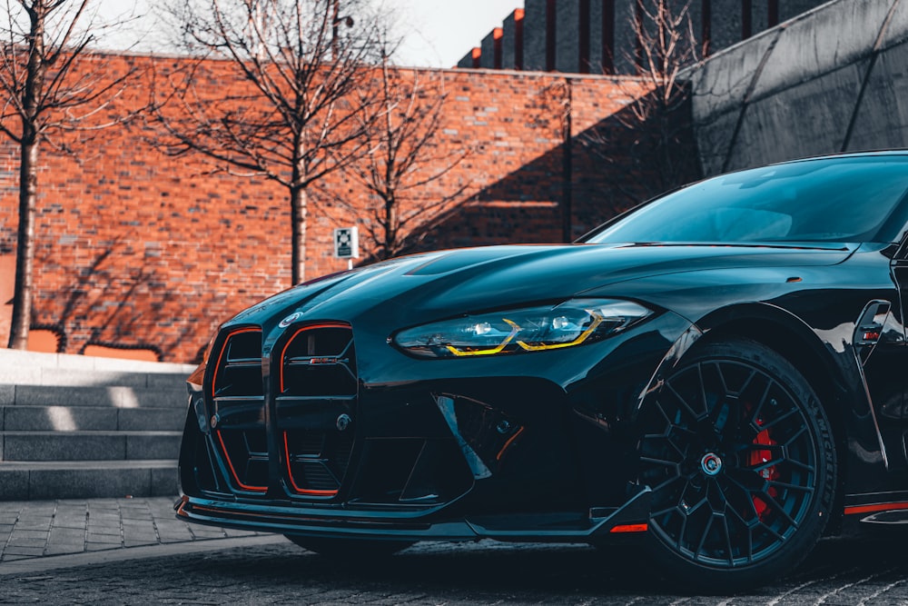 a black sports car parked in front of a brick building