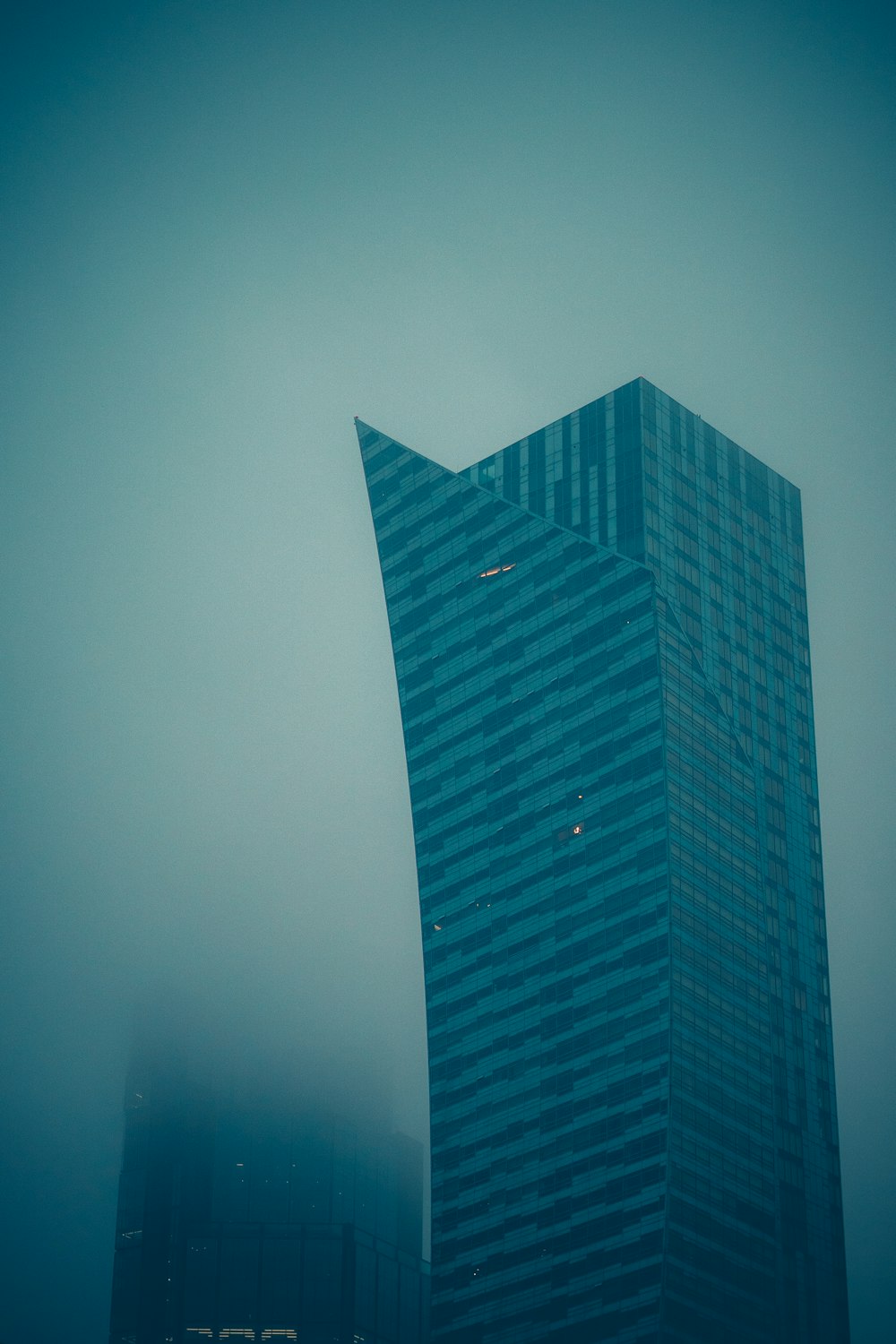 a very tall building in the middle of a foggy sky