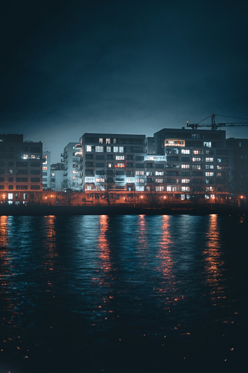 a city at night with lights reflecting in the water