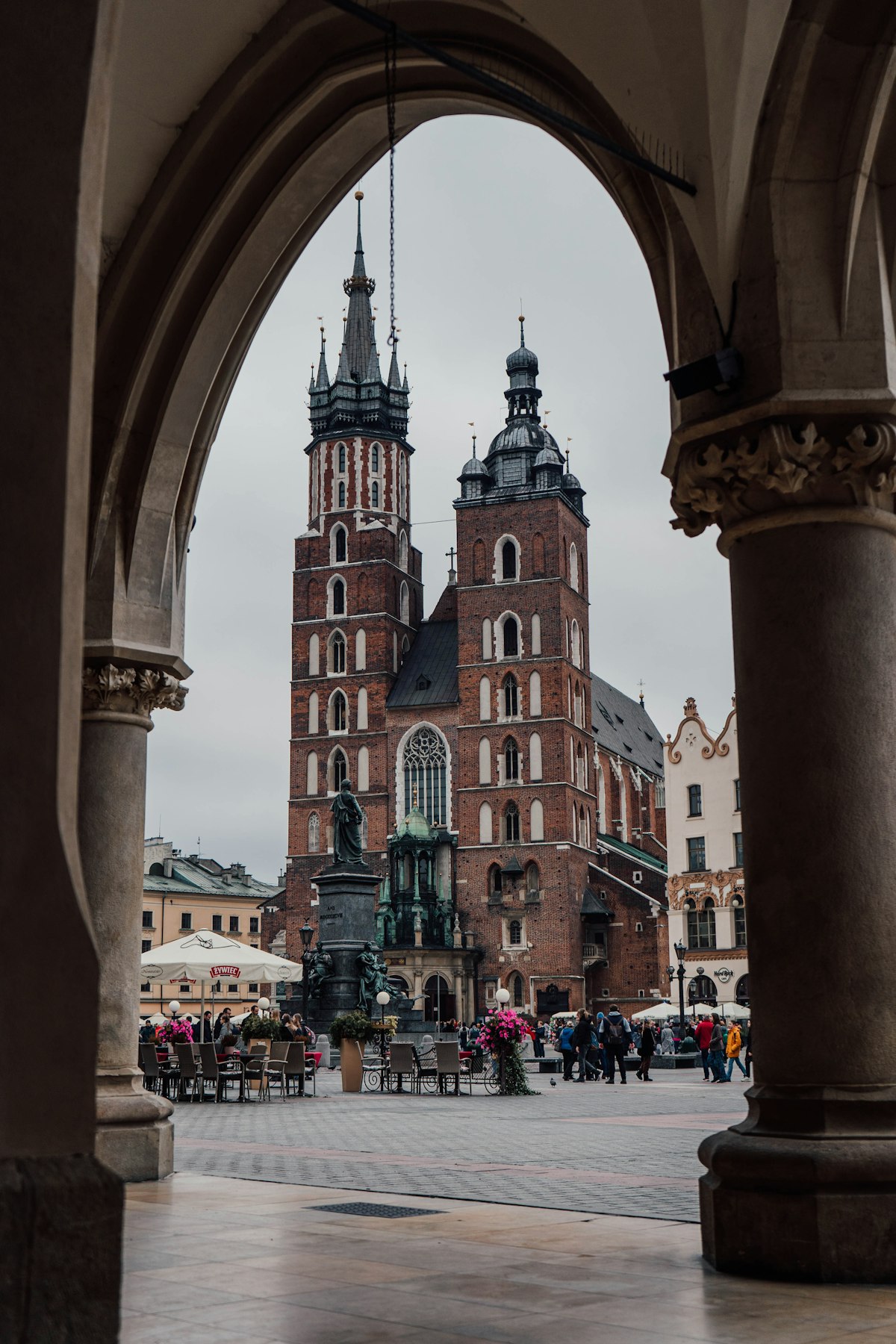 Kraków October — St Mary's Basilica framed through the arches of the Cloth Hall in autumn