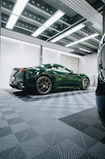 a green sports car parked in a garage