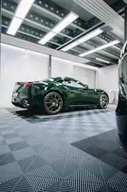 a green sports car parked in a garage