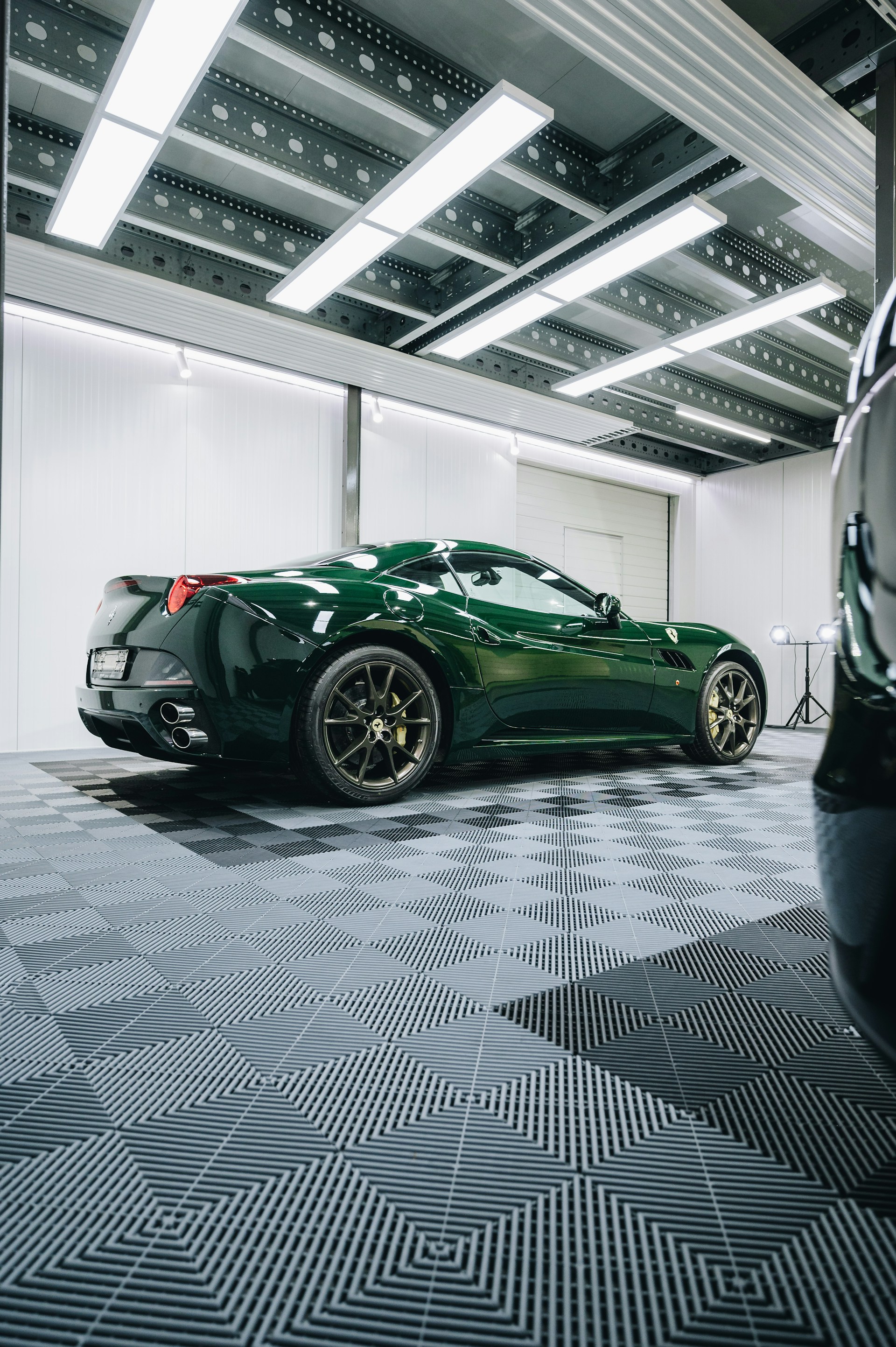 a green sports car parked in a garage