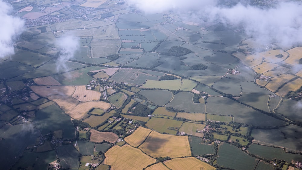 an aerial view of a field with clouds in the sky