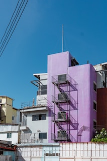 a purple building with a fire escape next to it