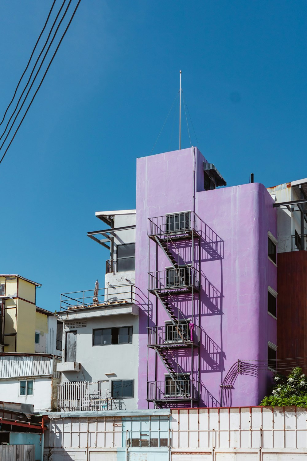 a purple building with a fire escape next to it