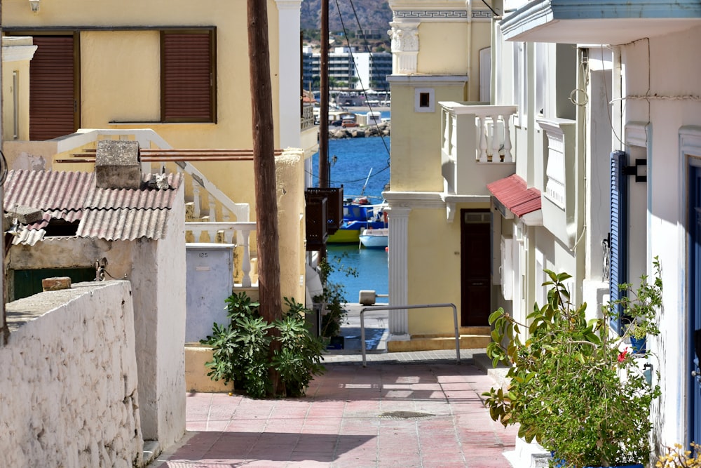 a narrow street with a few buildings and boats in the water