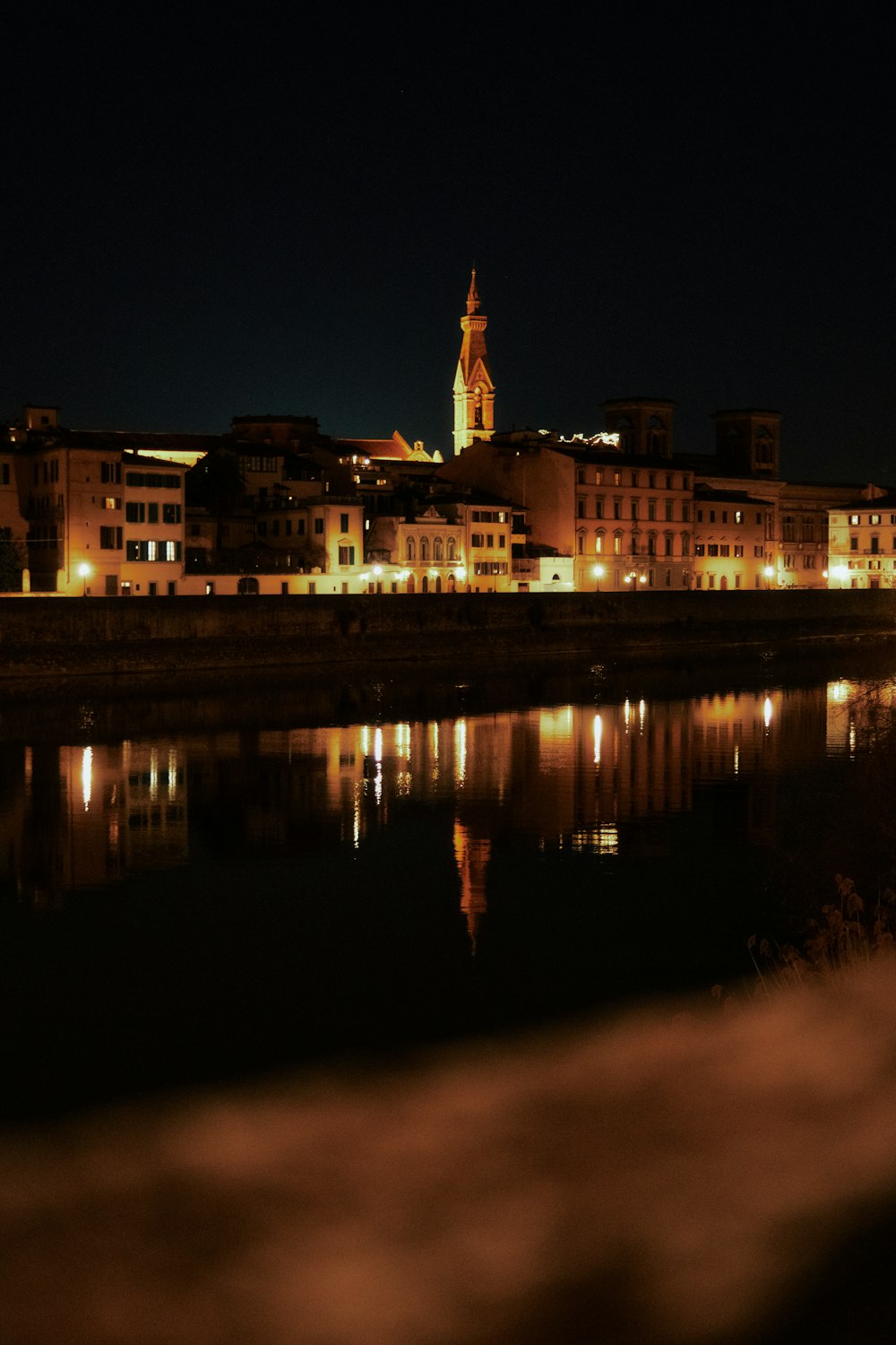 a city at night with a clock tower in the background