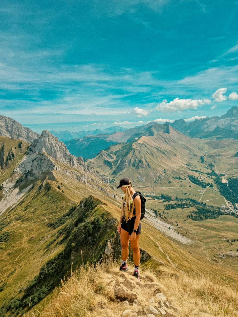 a person standing on a hill with mountains in the background