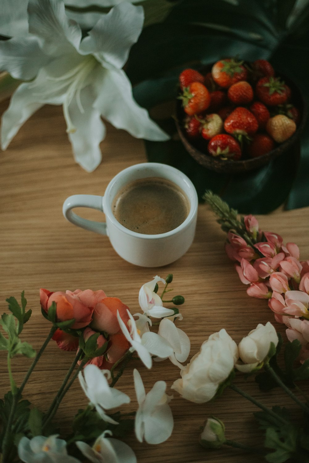 a cup of coffee next to some flowers