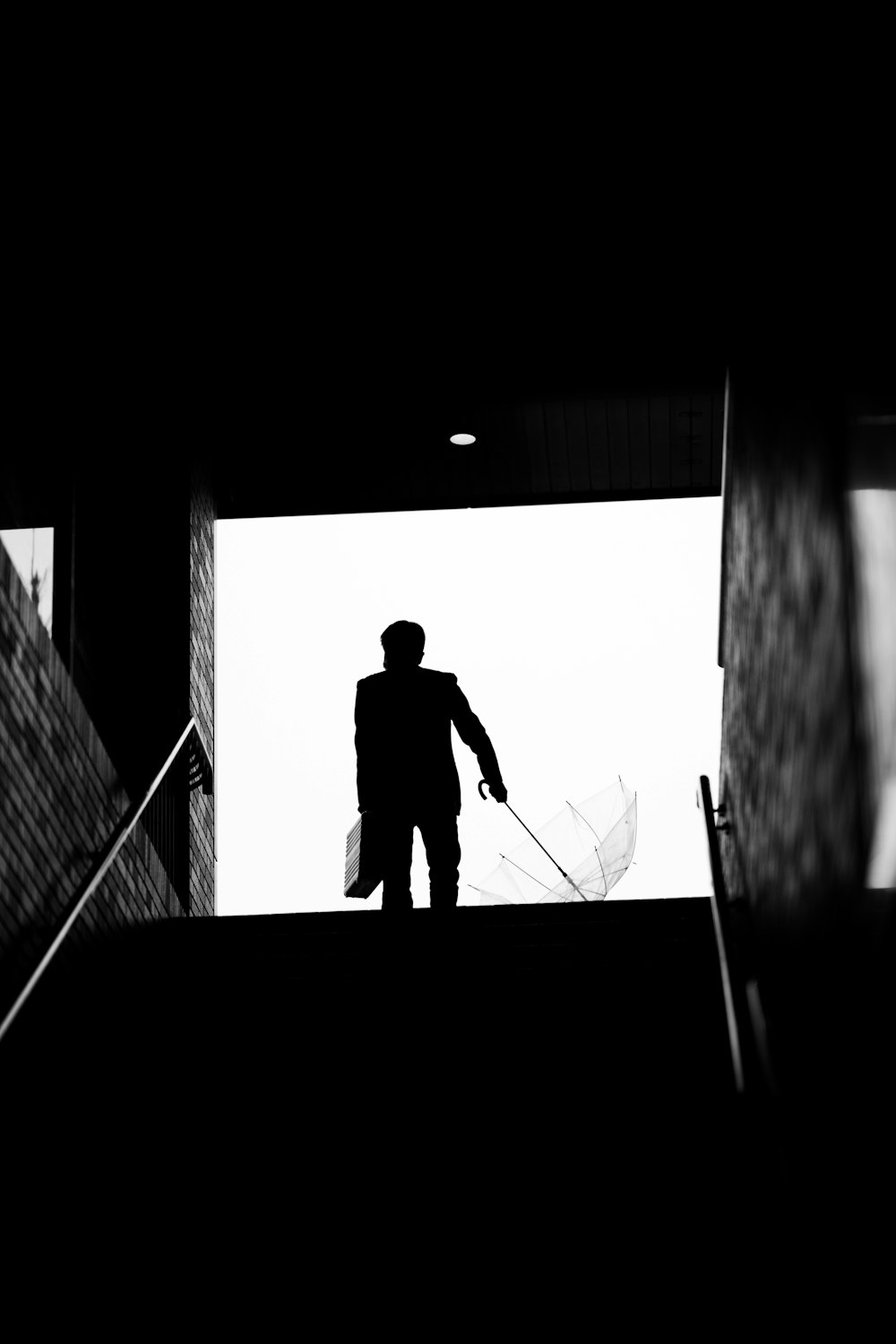 a silhouette of a man walking up a flight of stairs