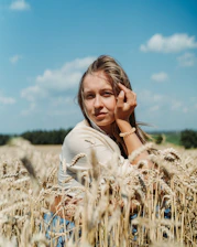 a woman sitting in a field of wheat
