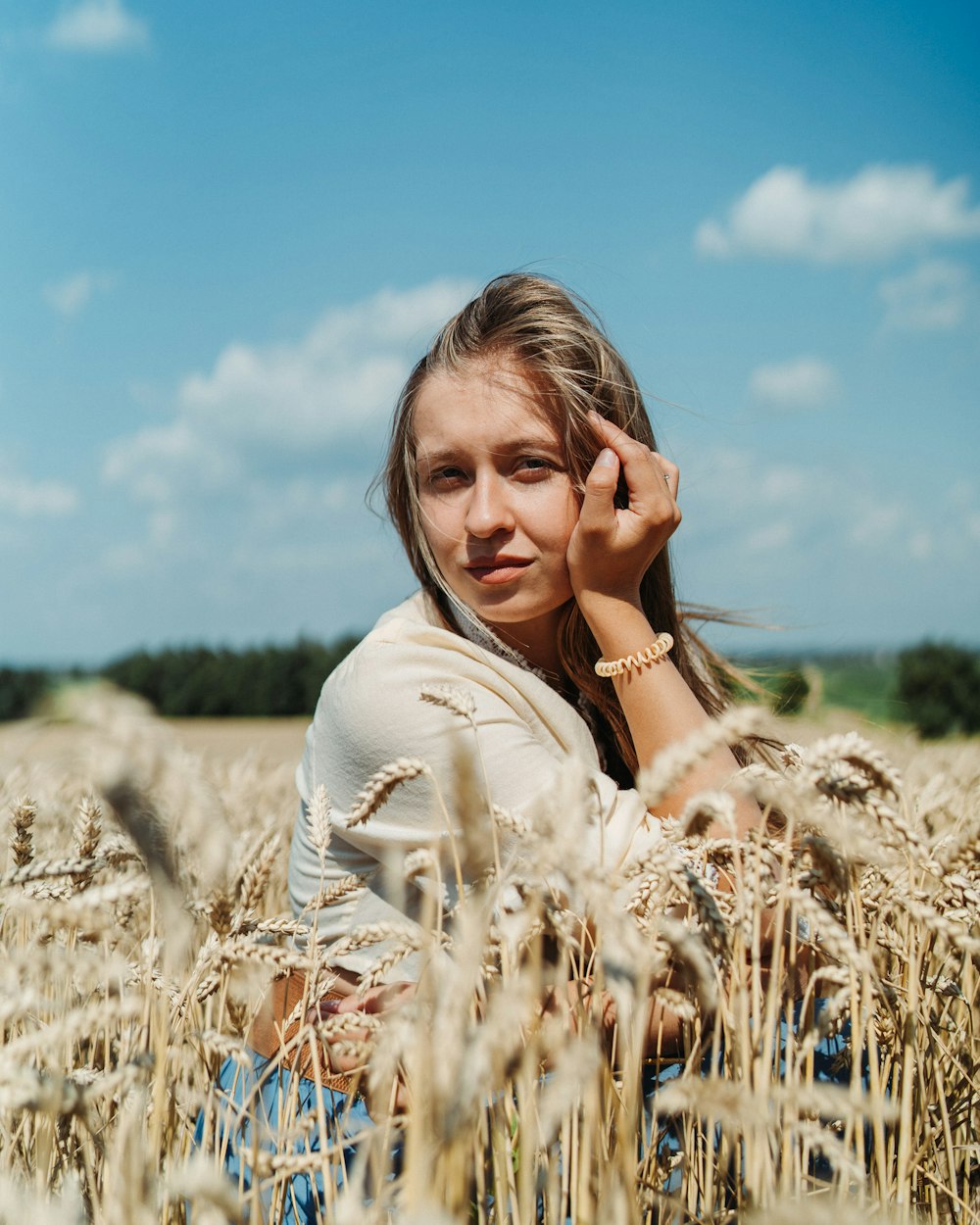 a woman sitting in a field of wheat