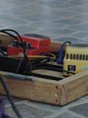 A row of handcrafted guitar pedals lined up on a rustic wooden table.