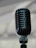 Close-up of a sleek black microphone stand holding a vintage-style mic.