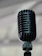 Close-up of a sleek black microphone stand holding a vintage-style mic.