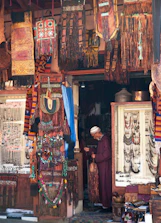Handcrafted African textiles and sculptures arranged in a boutique retail setting.