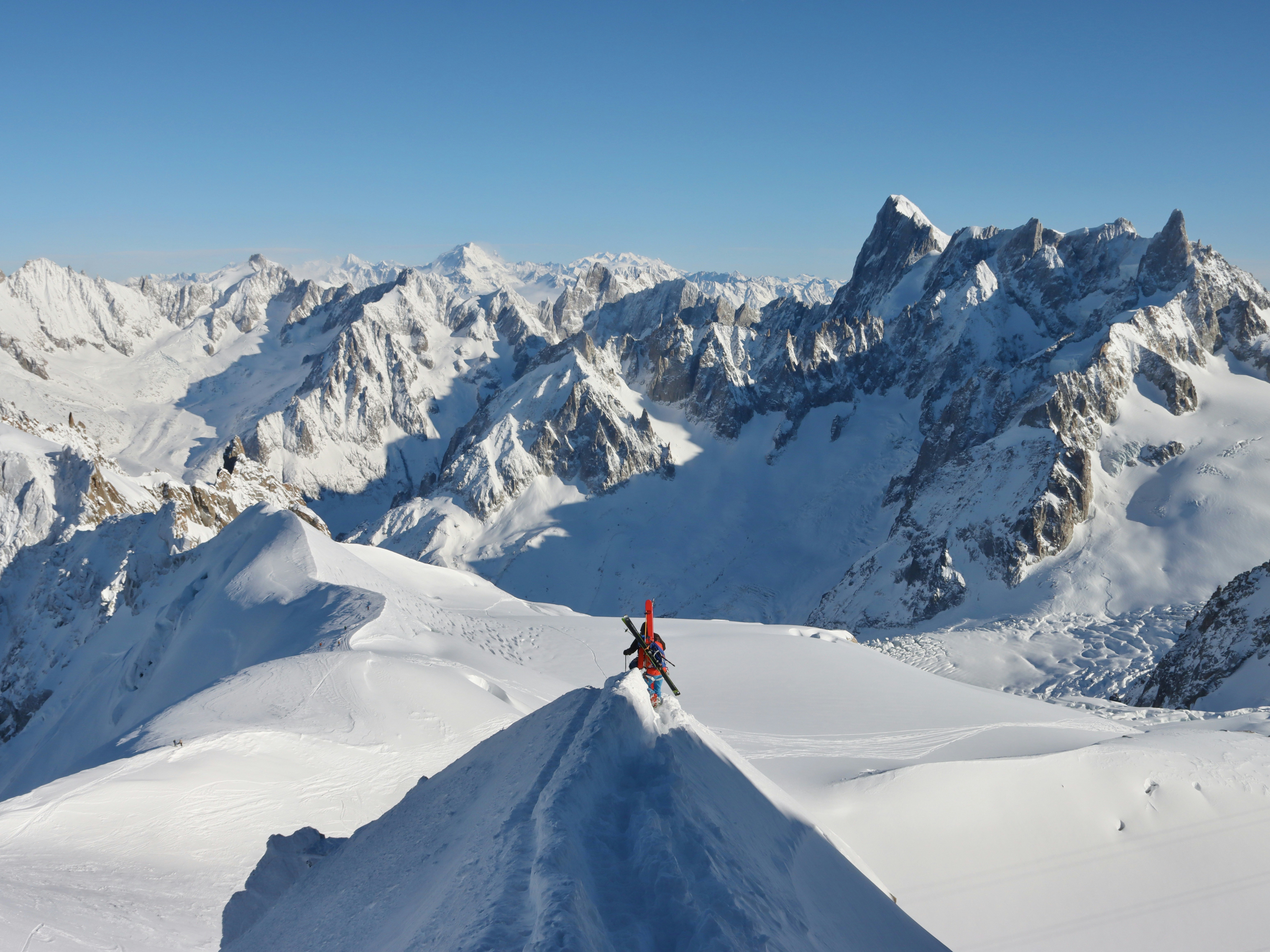 Un hombre montando esquís por la ladera de una pendiente cubierta de nieve