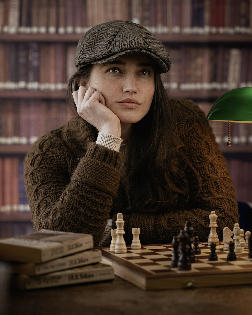 a woman sitting at a table with a chess board