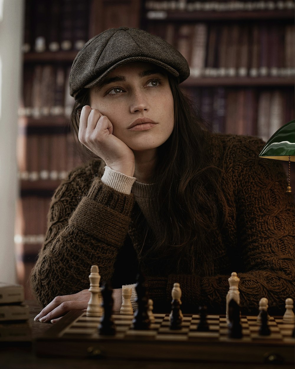 a woman sitting at a table with a chess board