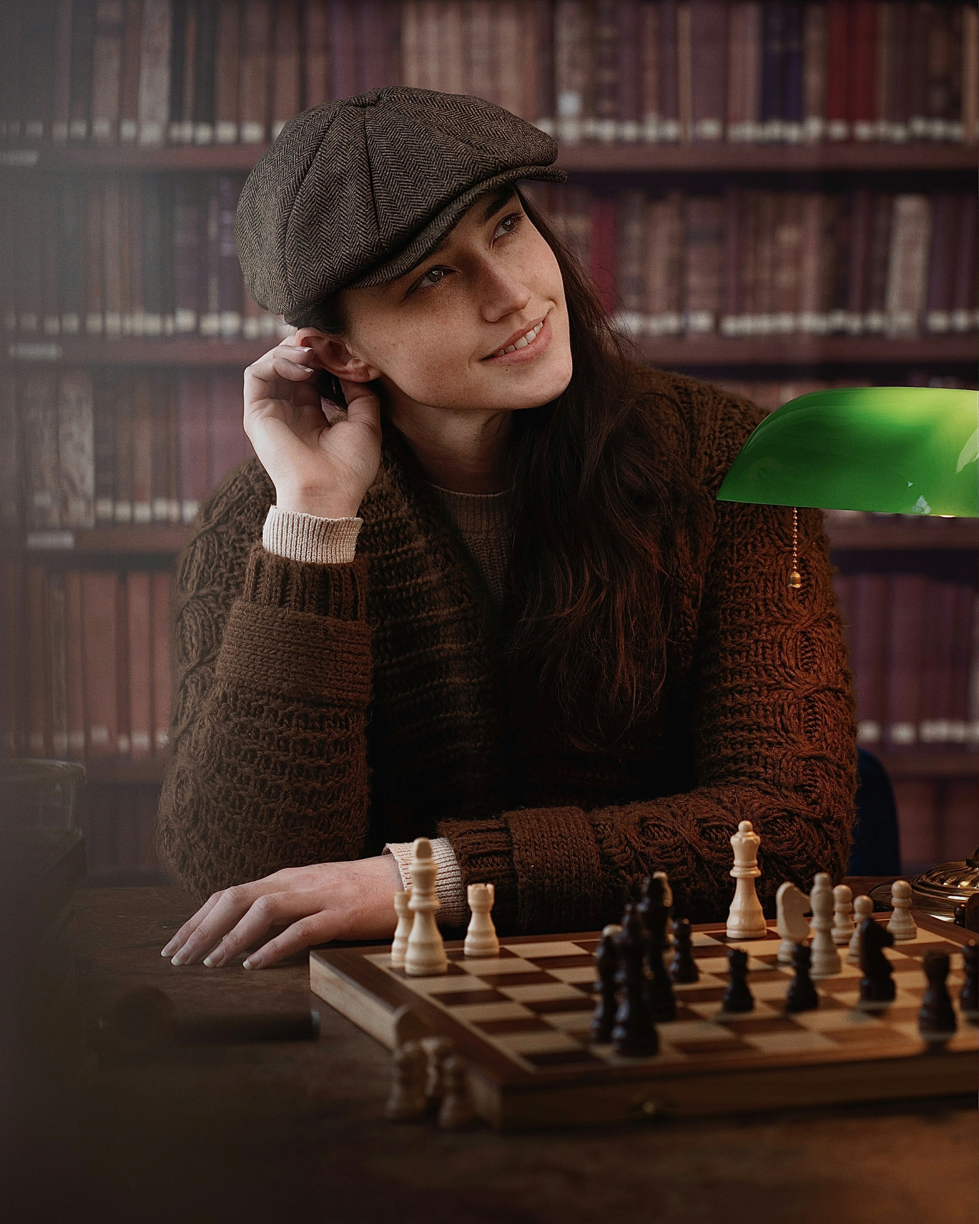a woman sitting at a table with a chess board