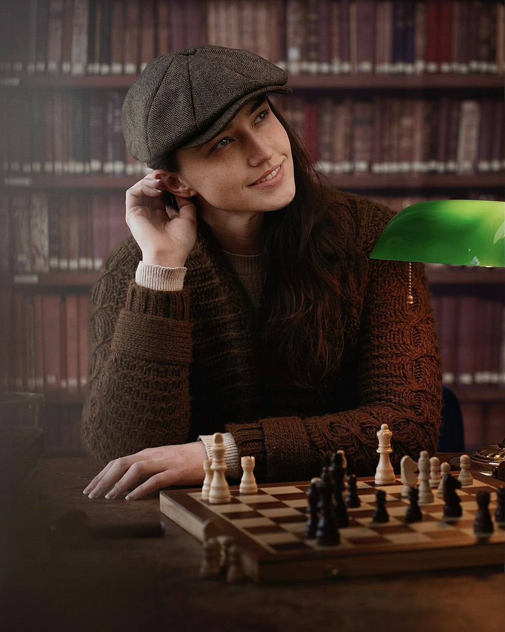a woman sitting at a table with a chess board