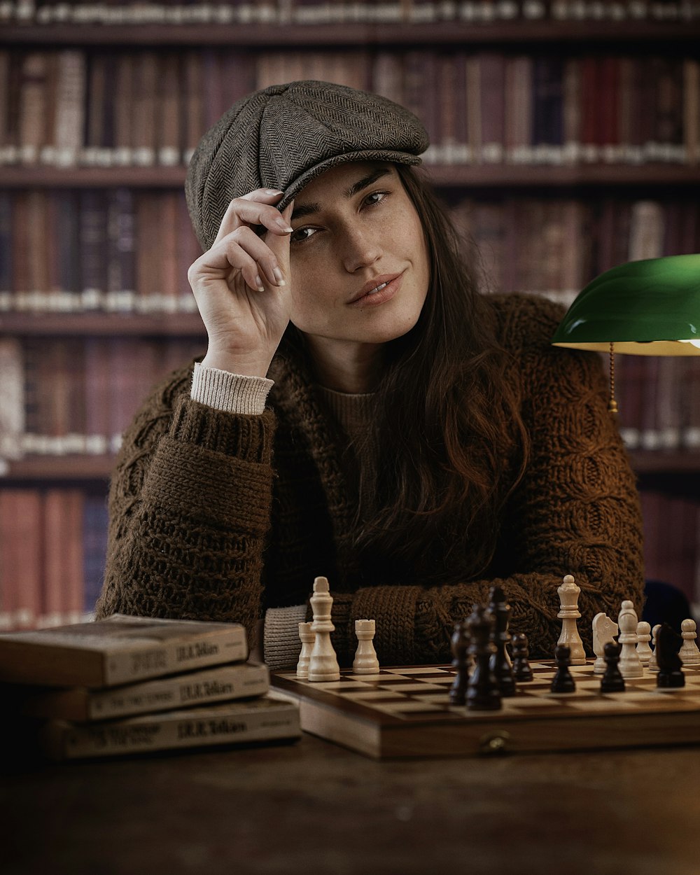 a woman sitting at a table with a chess board