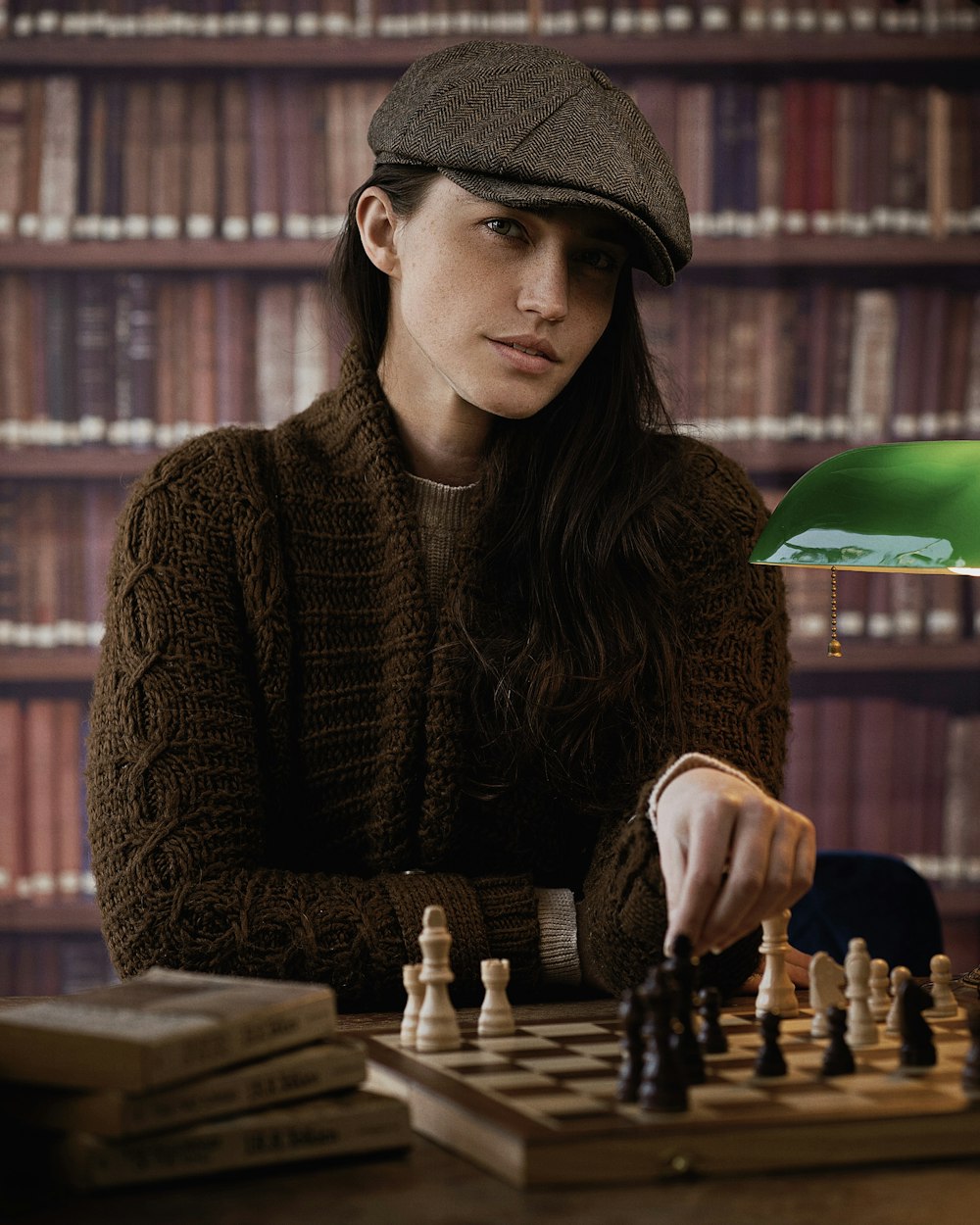 a woman sitting at a table playing a game of chess
