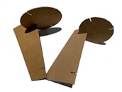 A colorful display of finished cardboard models arranged on a textured cardboard background.