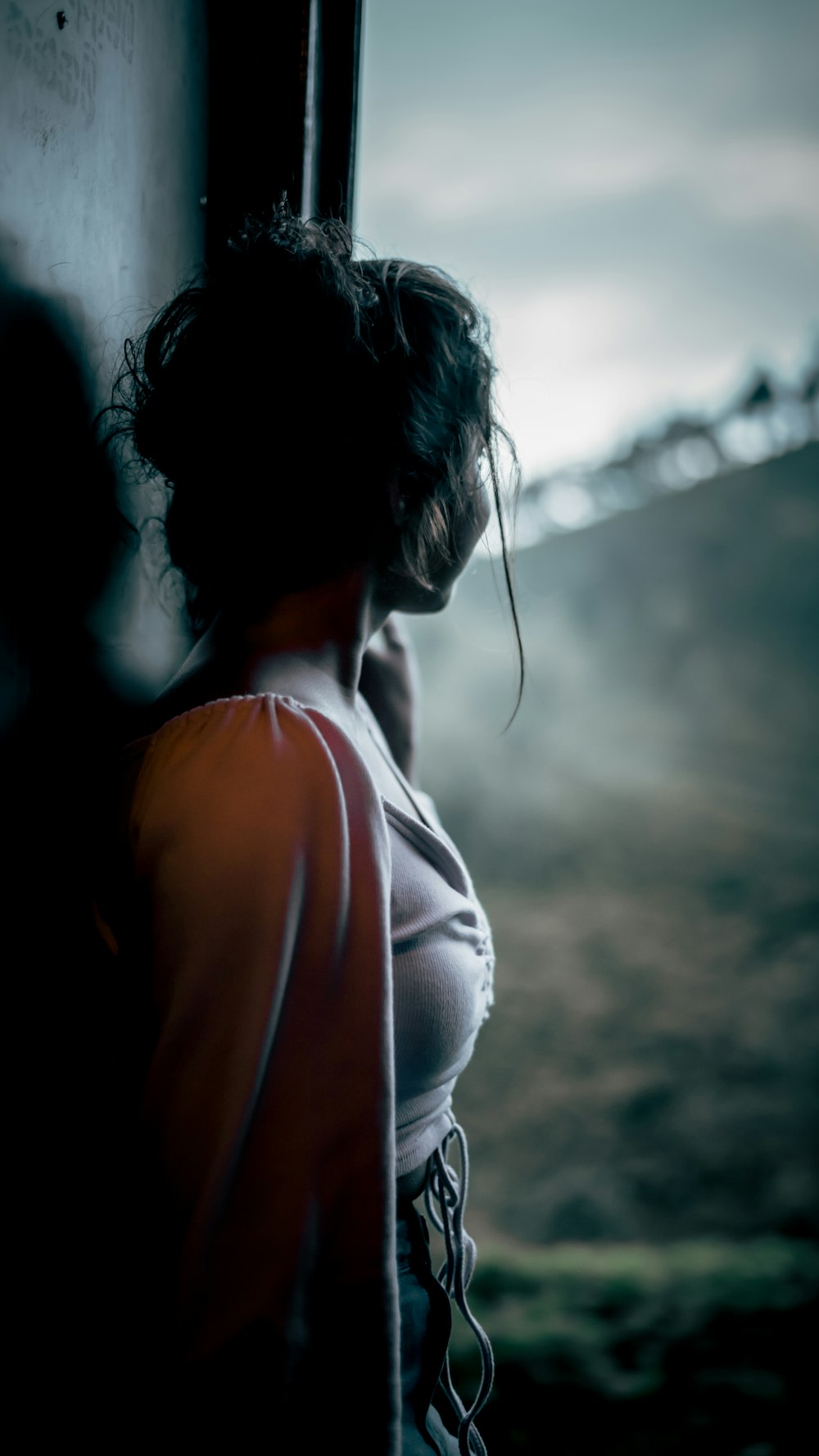 a woman leaning against a wall with her head down