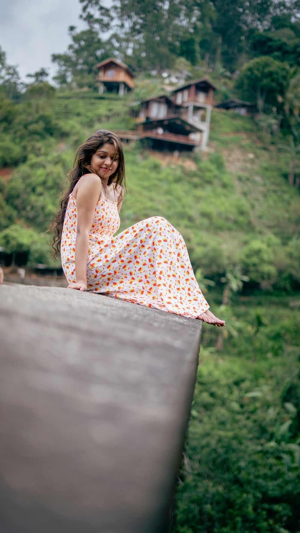 a woman in a dress sitting on a ledge