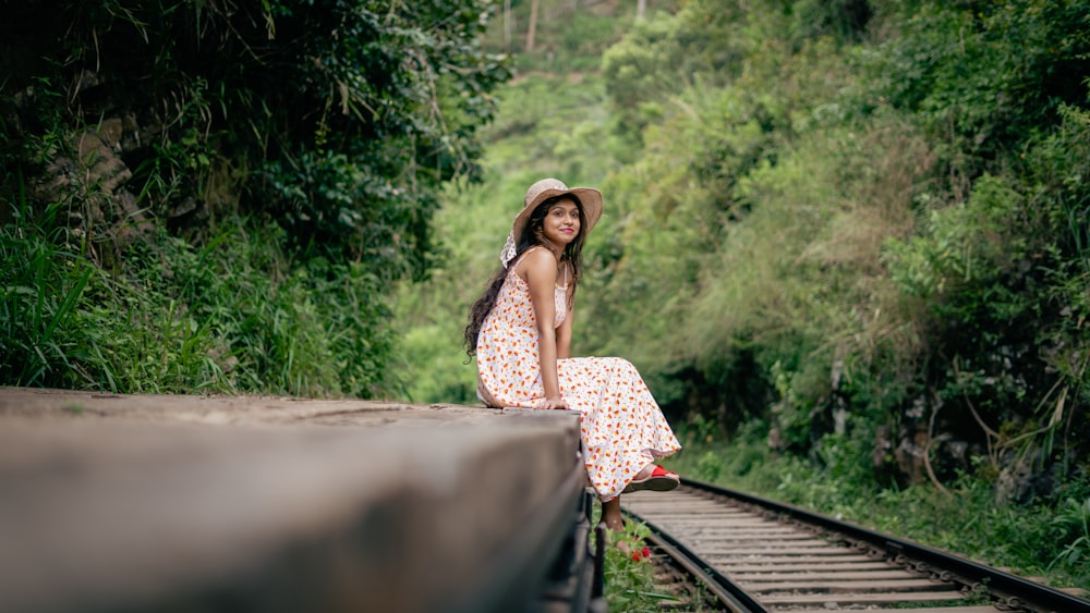 a woman is sitting on a train track