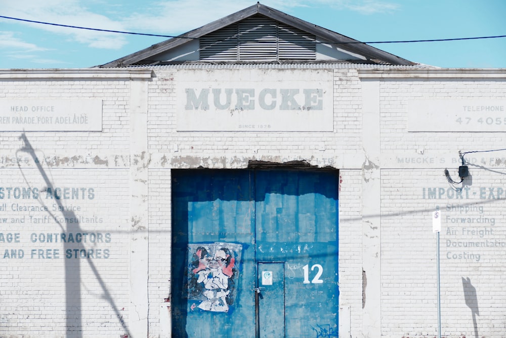 an old building with a blue door and graffiti on it